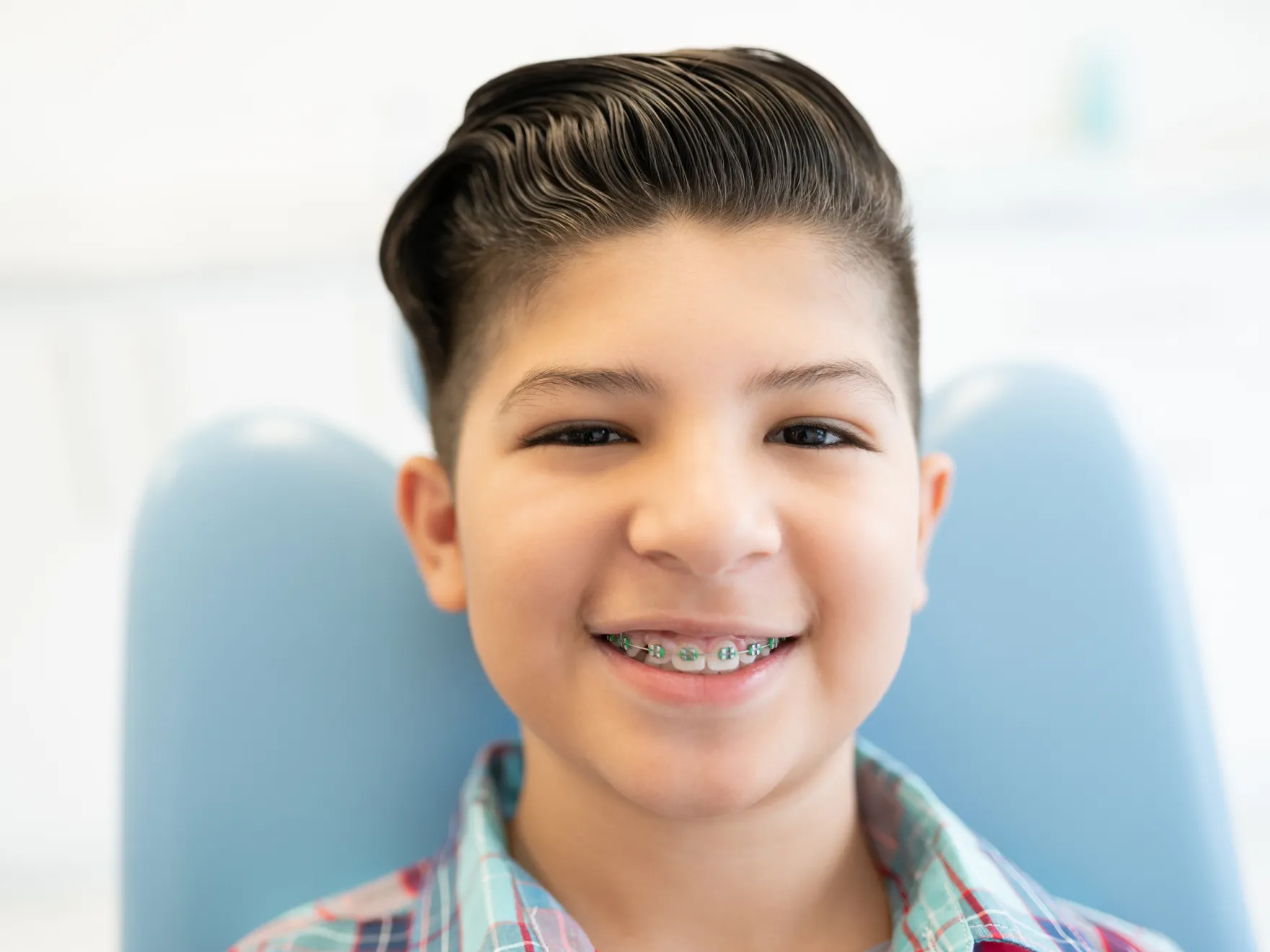 Braces in New York, NY | boy with braces sitting in a dentist chair, smiling