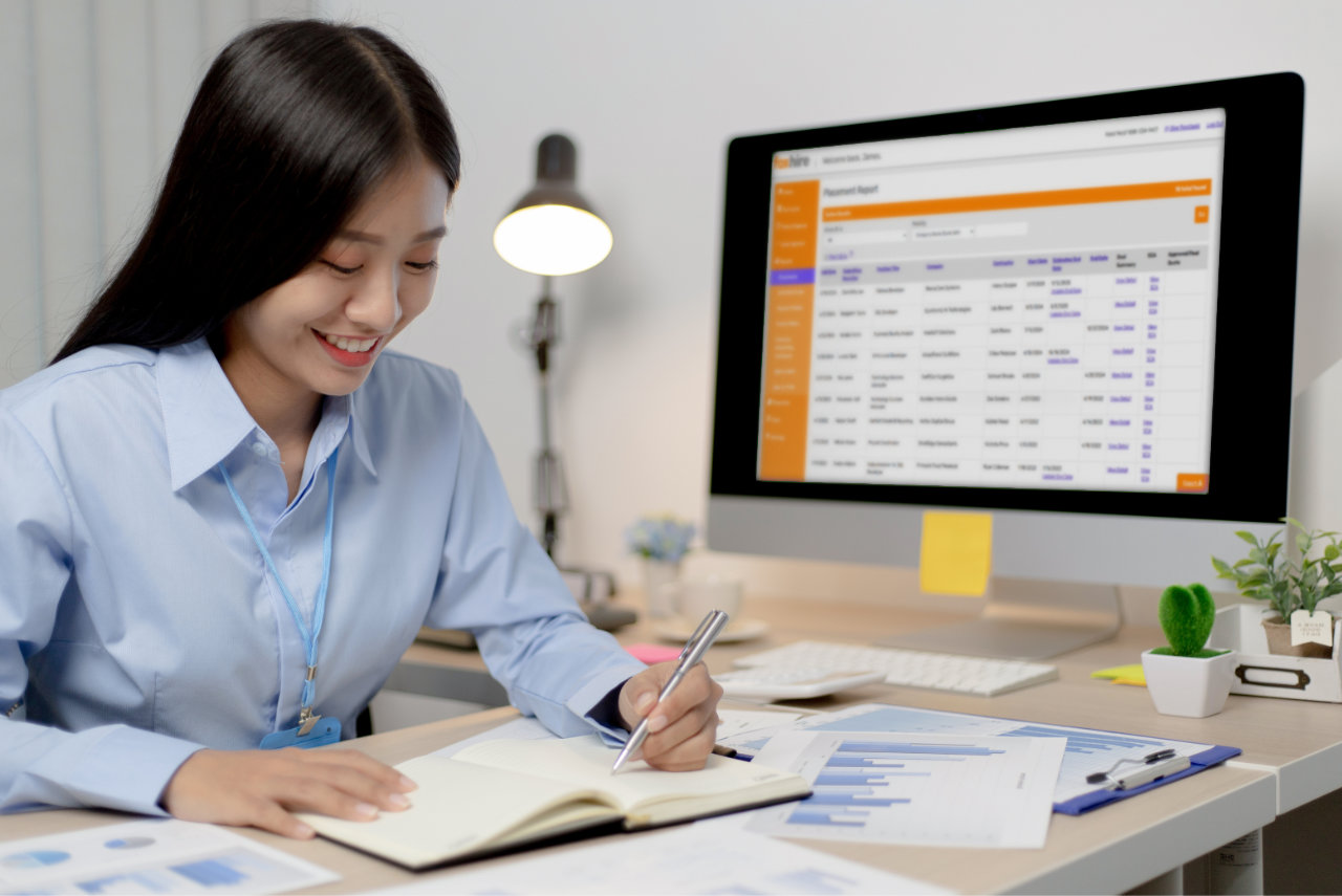 Smiling professional working on financial reports at modern office desk