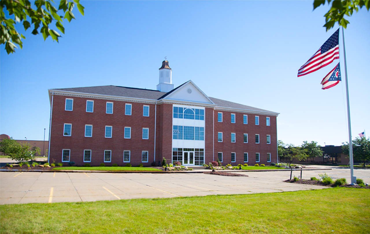Brick government building with American flags on sunny day