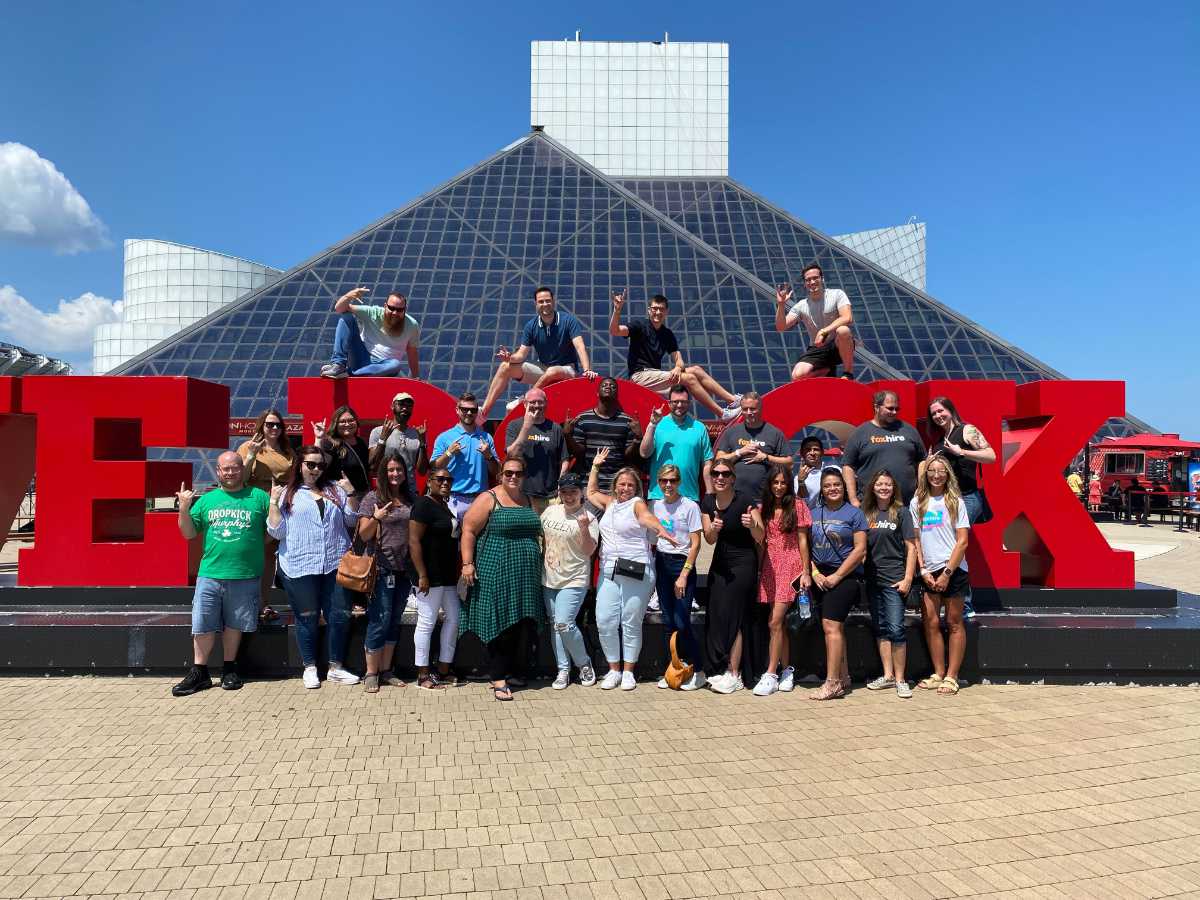 Group photo in front of Rock and Roll Hall of Fame with large red ELEVATE letters