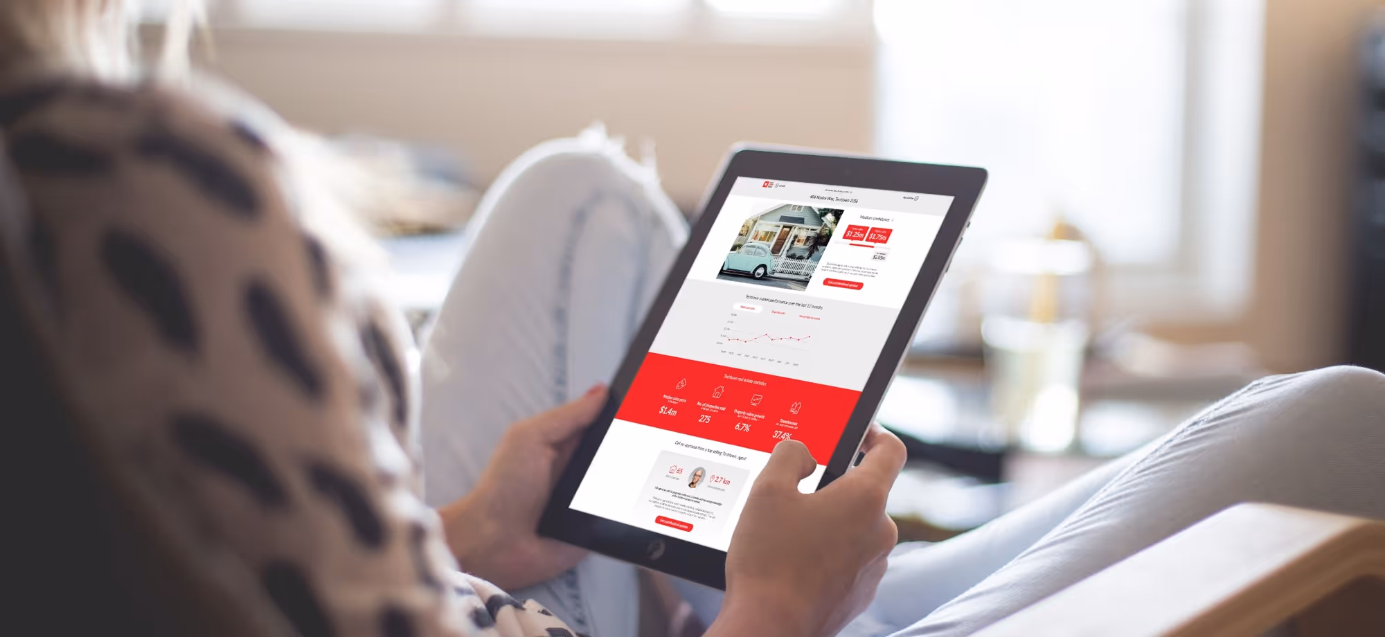 A person sitting on a couch holding a tablet.