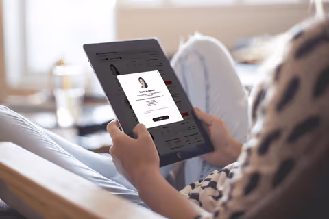 A person sitting in a chair holding a tablet.