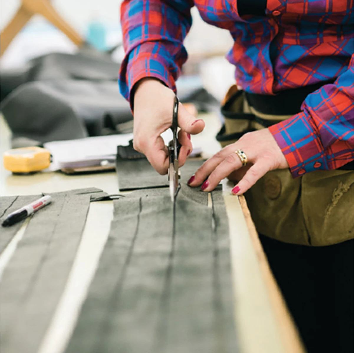 Artisan cutting fabric by hand as part of the upholstery process at Alfred’s, showcasing bespoke upholstery, custom furniture creation, and the brand’s luxury design process rooted in craftsmanship.