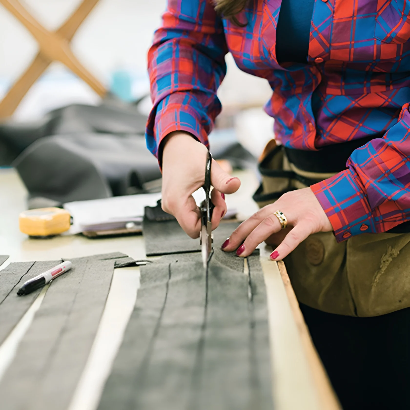 Artisan cutting fabric by hand as part of the upholstery process at Alfred’s, showcasing bespoke upholstery, custom furniture creation, and the brand’s luxury design process rooted in craftsmanship.