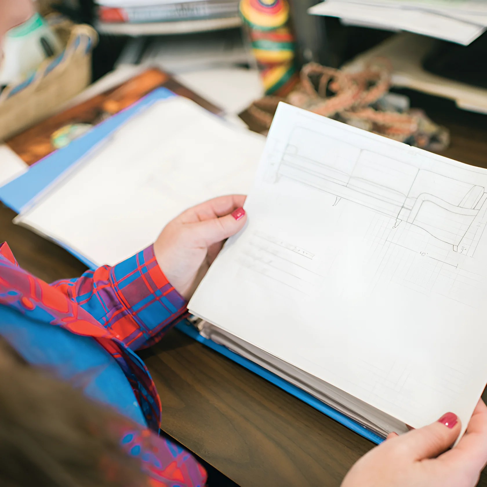 Designer reviewing custom furniture blueprints as part of Alfred’s craftsmanship process, illustrating bespoke upholstery, luxury design planning, and detailed upholstery process documentation.