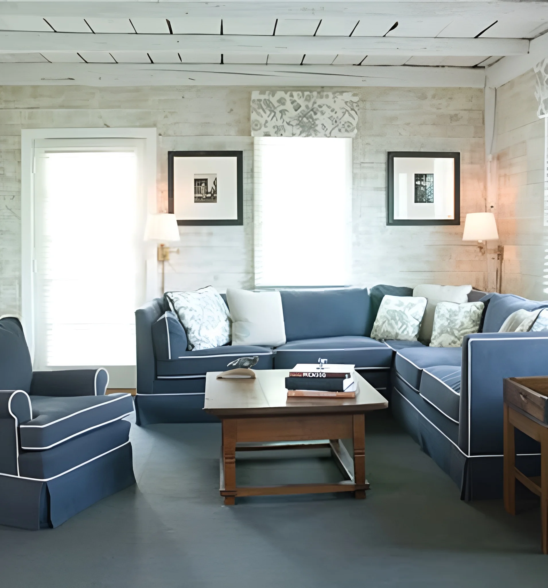 Coastal living room featuring custom upholstery on a navy sectional and armchair by Alfred’s by Land, showcasing home upholstery, luxury furniture, and heritage craftsmanship.