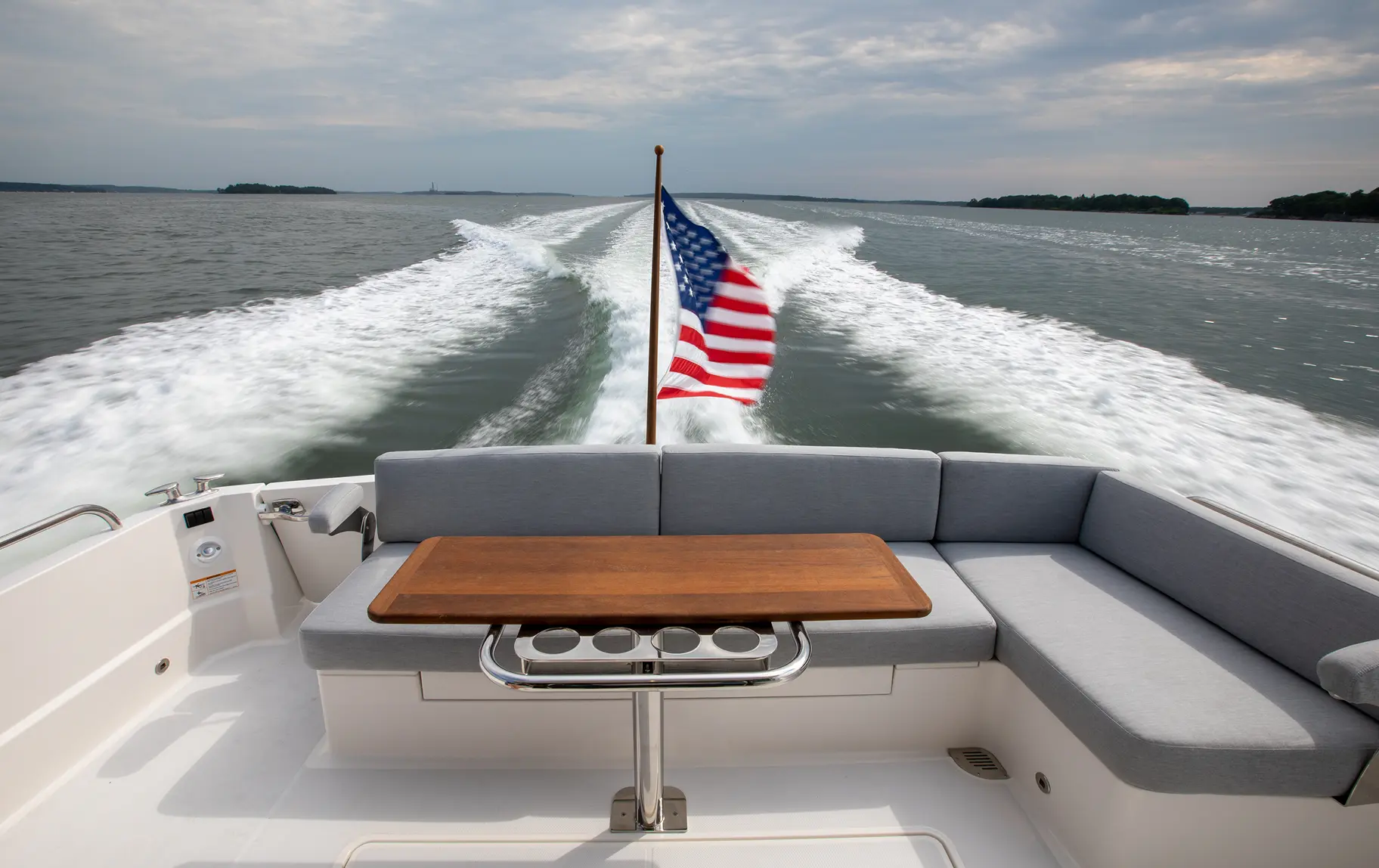 American flag waving from a luxury yacht featuring Alfred’s custom marine upholstery and elegant built-in seating.