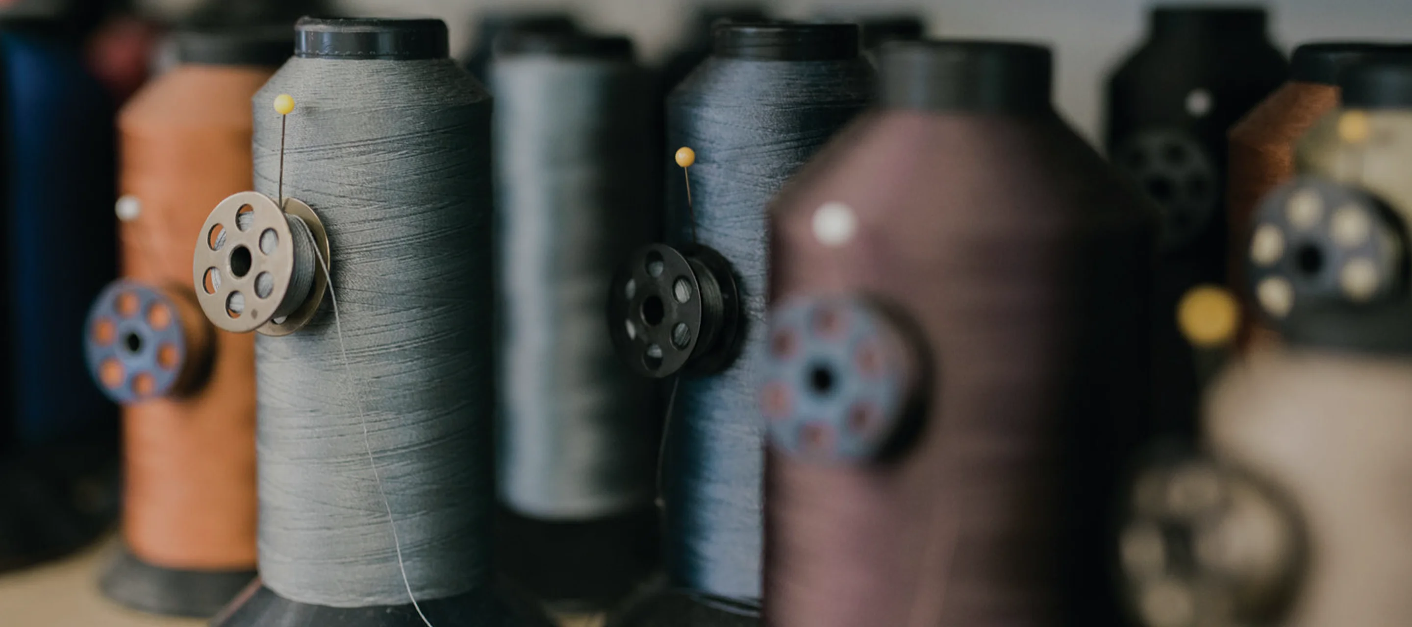 Thread spools in a workshop at Alfred’s by Land, symbolizing the heritage craftsmanship behind custom upholstery, home upholstery, and luxury furniture.