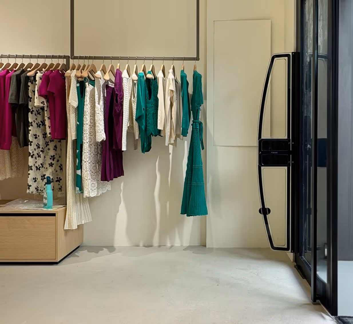 Modern clothing store interior with neatly folded jeans on shelves and racks of shirts and jackets.