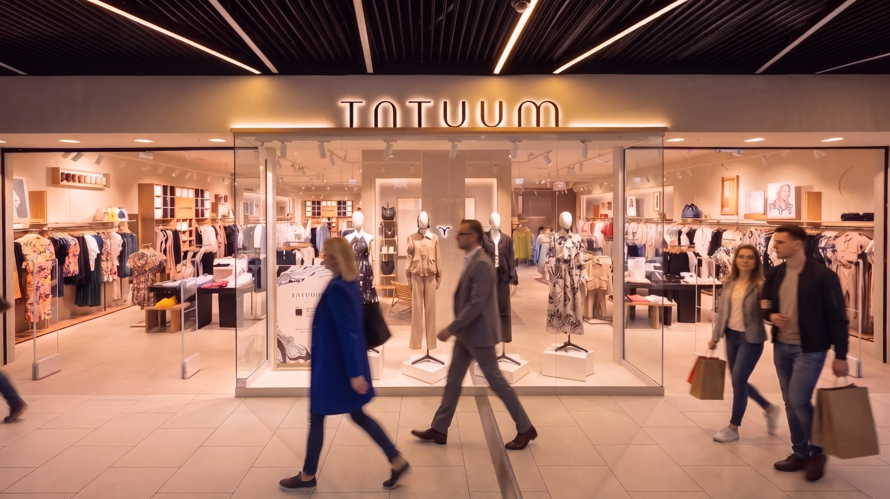 Modern clothing store interior with neatly folded jeans on shelves and racks of shirts and jackets.
