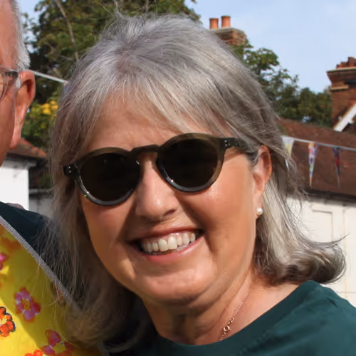 Profile photo of a woman smiling outside with sunglasses on