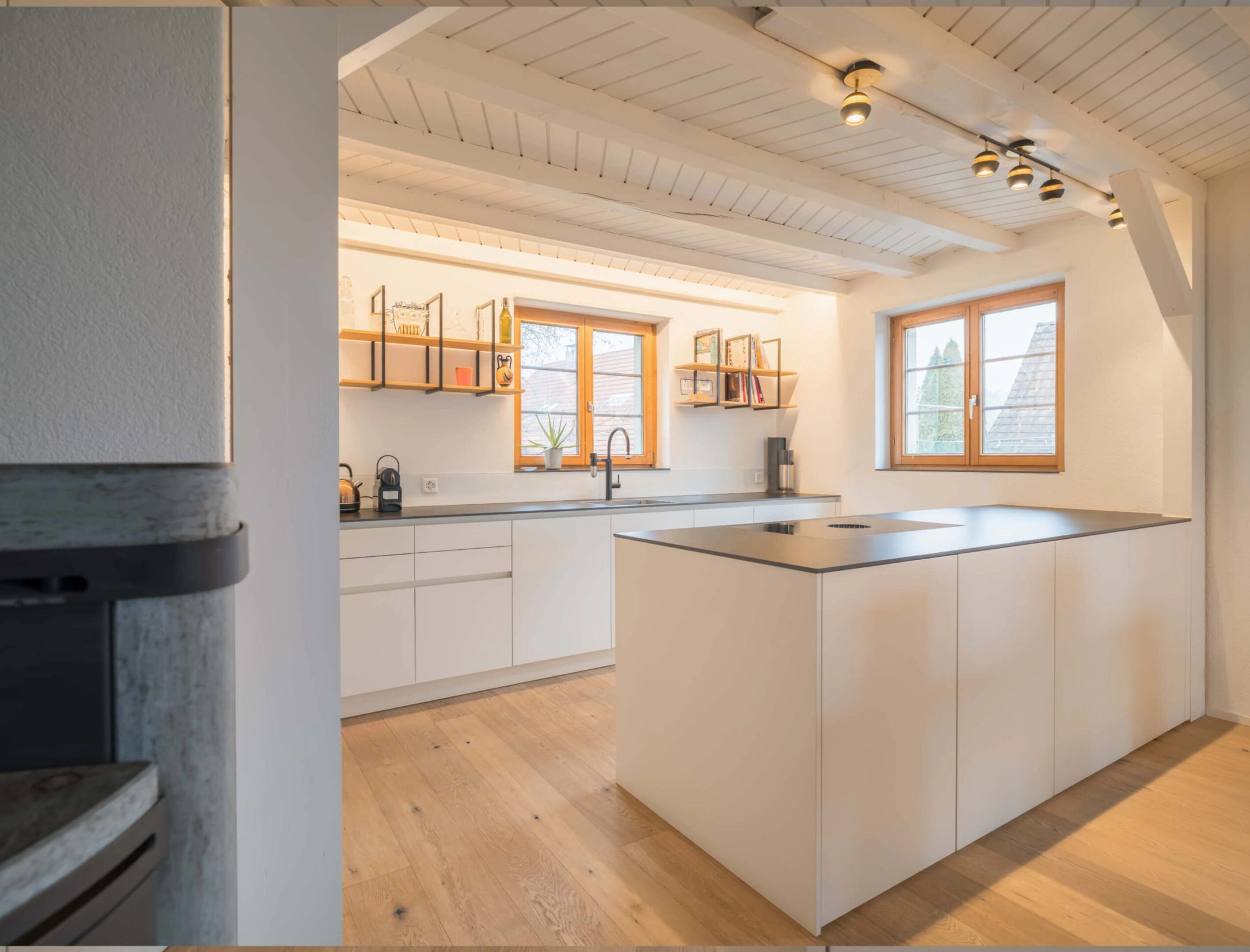 Moderne weiße Küche mit Holzboden und Holzfenstern, offene Regale