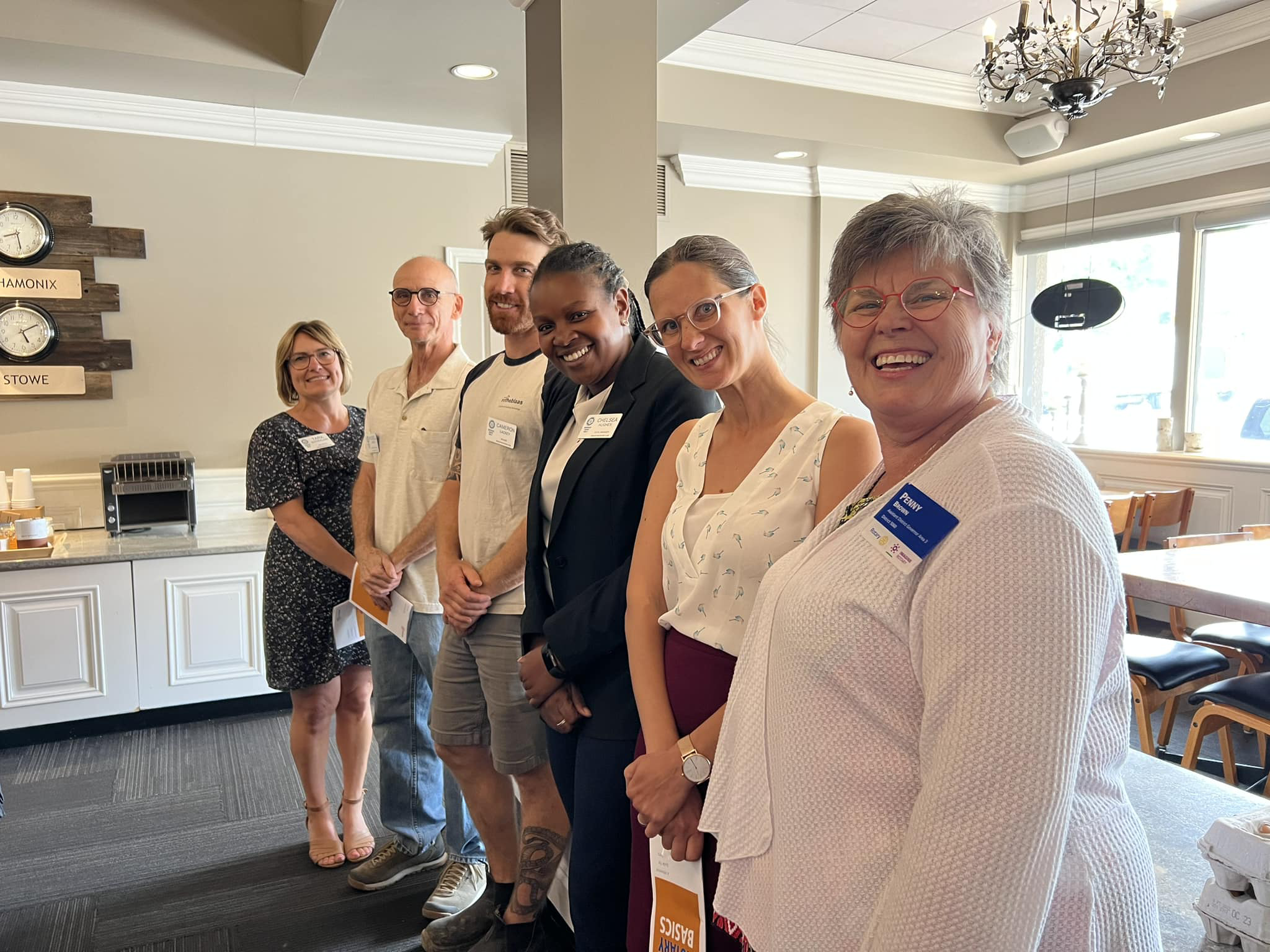 group of six people standing in a line smiling