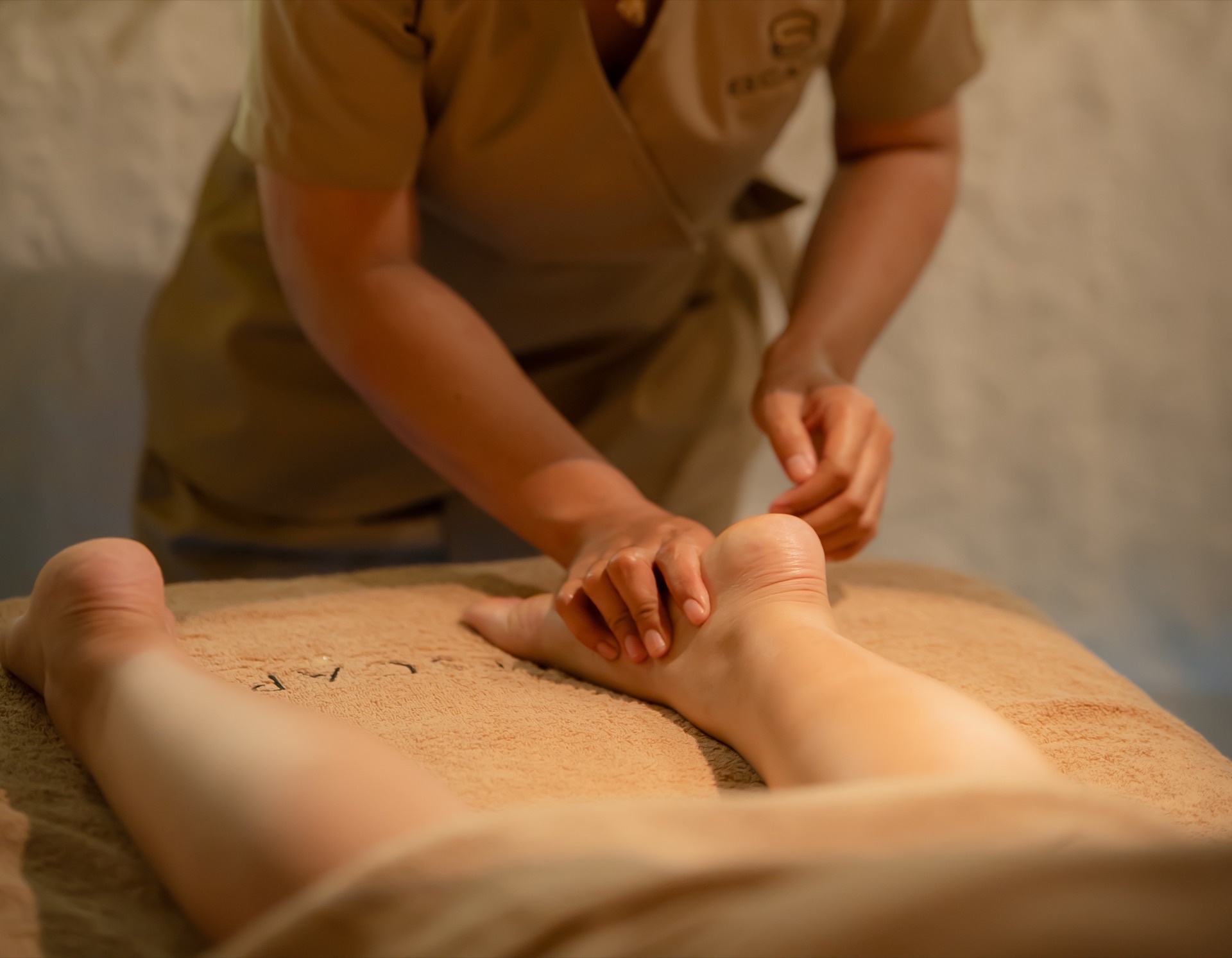 Therapist applying focused pressure to a guest's lower leg during a sports massage at Escape 8 Spa.