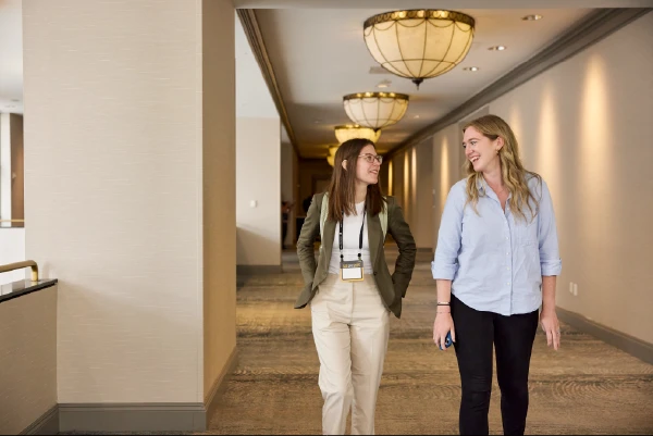 Two team members conversing at a conference.