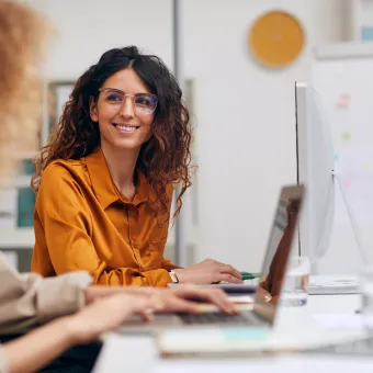 young women collaborating in front of a computer screen