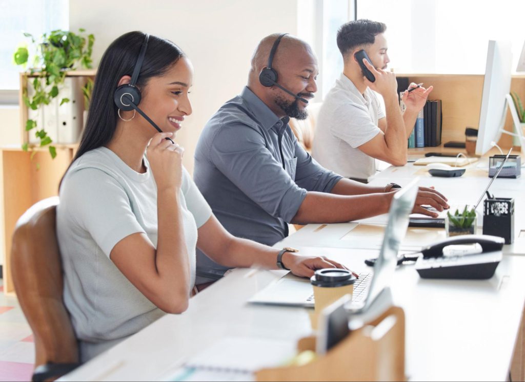 Smiling customer support team working in an office