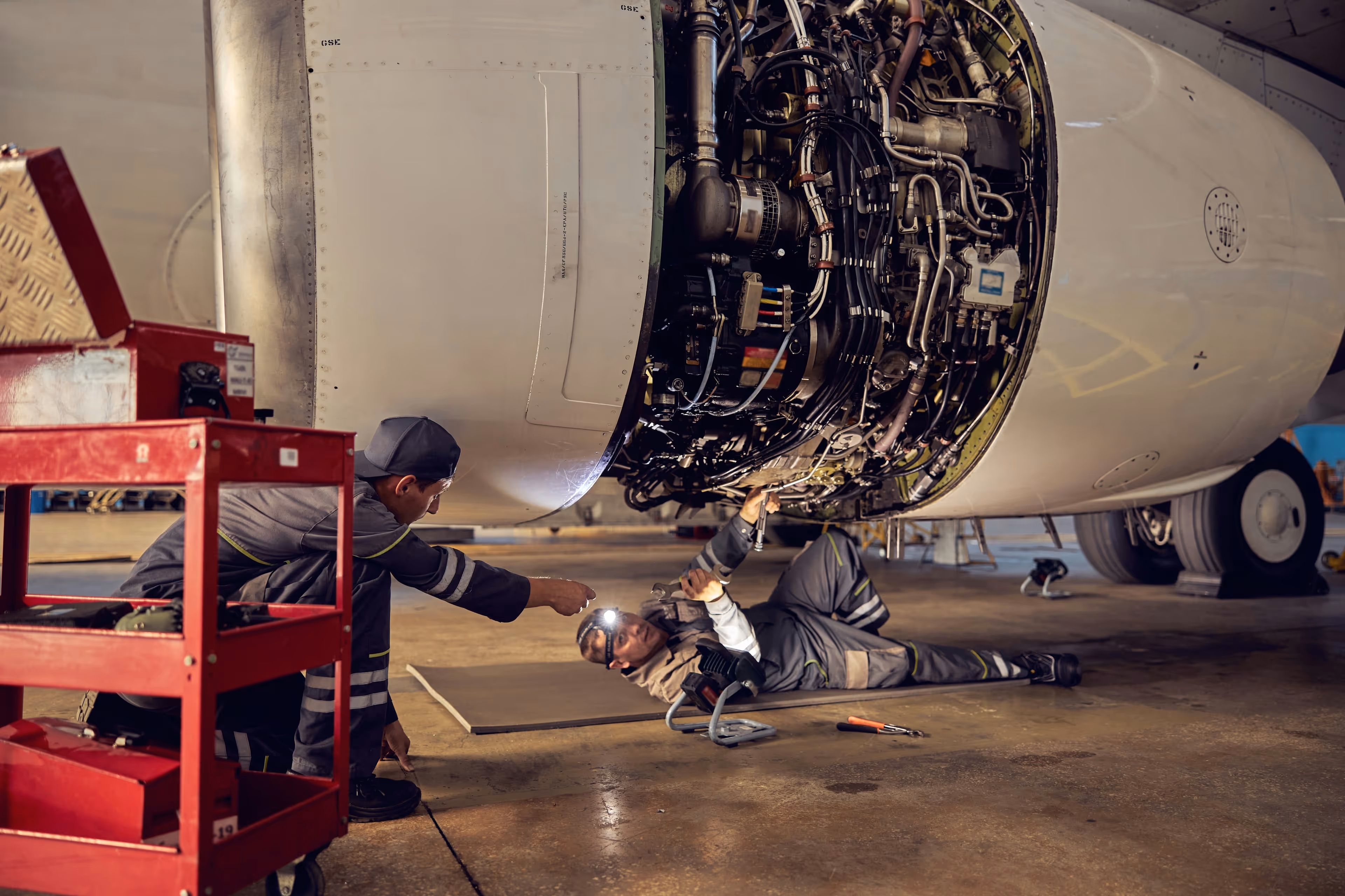 Maintenance technician working on an exposed aircraft engine.