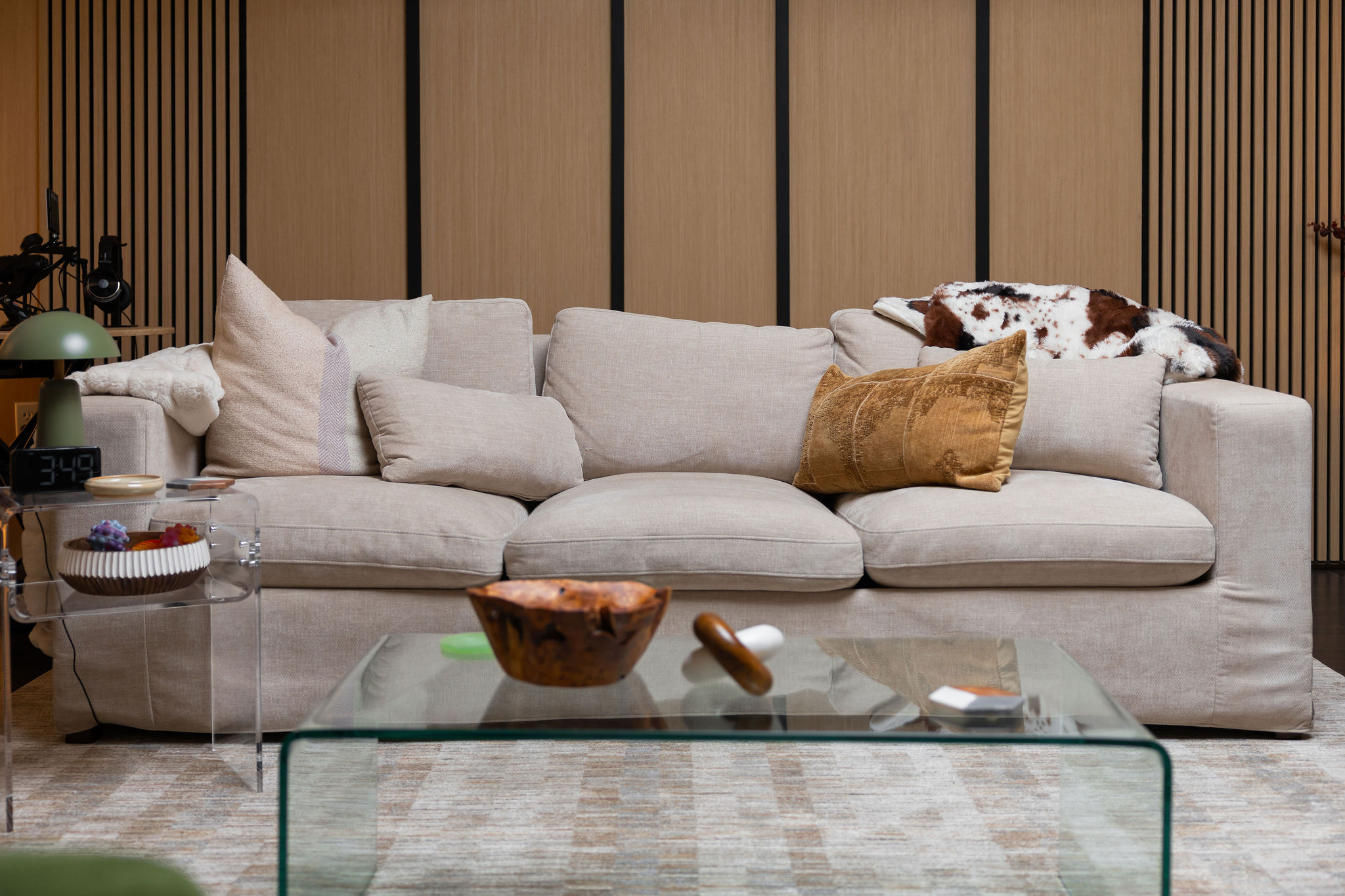 Clear Mind's therapy office featuring a beige sofa with beige decorative pillows, a black floor lamp, and a pastel abstract art