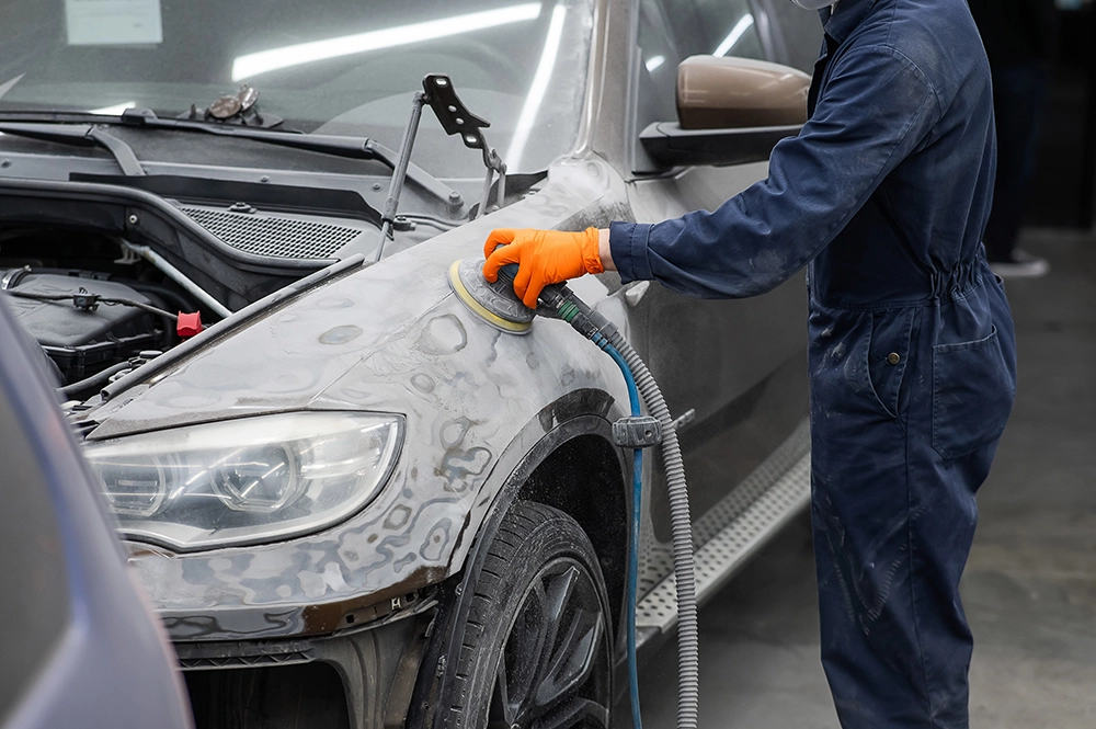 Technician sanding down a repair.