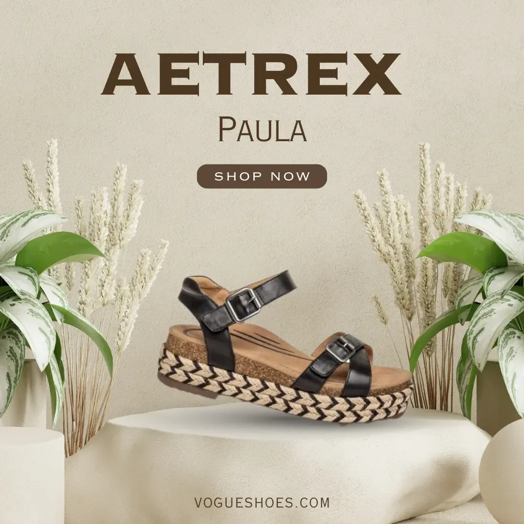 Aetrex Paula sandals displayed on a stone pedestal surrounded by plants. Text includes: 'Shop Now' and 'vogueshoes.com'.