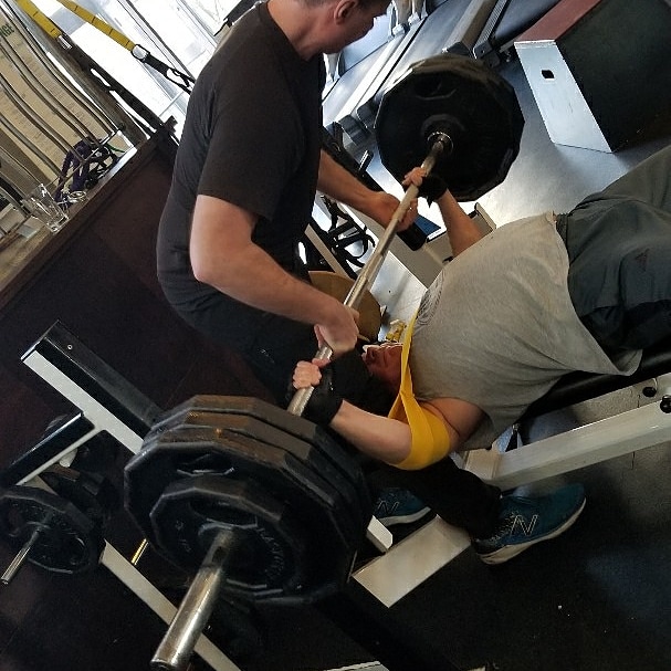 Personal trainer coaching advanced strength training with powerlifting and gravity-based exercises in a private Downtown Vancouver studio.