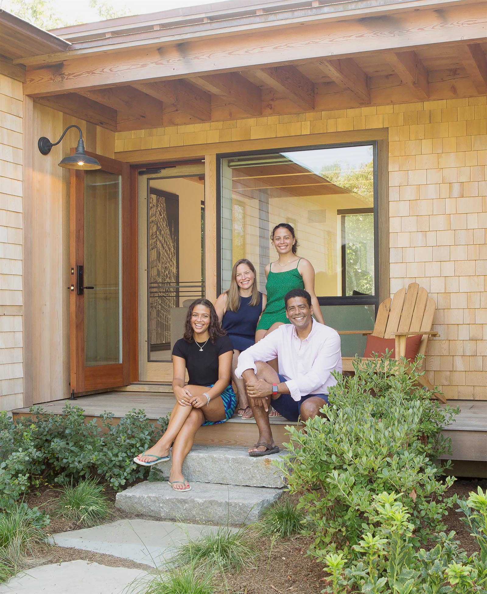 A family of four sitting on their front steps.