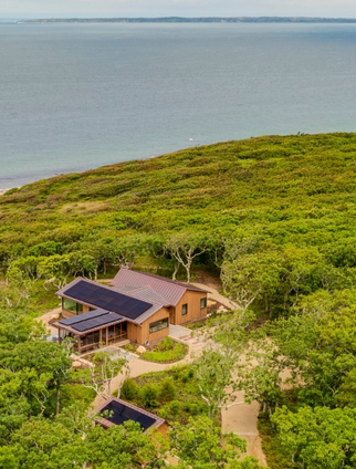 An aerial view of a house overlooking the water.
