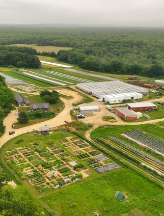 An aerial view of a farm with fields and outbulildings.