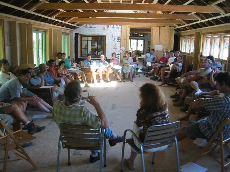 Book cover titled 'The Company We Keep' by John Abrams, showing people in a meeting room around a wooden table
