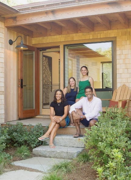 A family of four sitting on their South Mountain Company house's front steps.