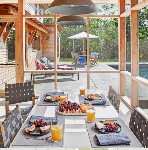 Breakfast on the screened porch overlooking the pool at a South Mountain Company house in West Tisbury