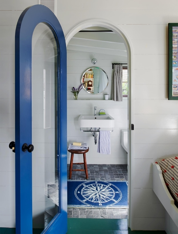 Whimsical cottage bathroo with vintage sink and  blue accents.