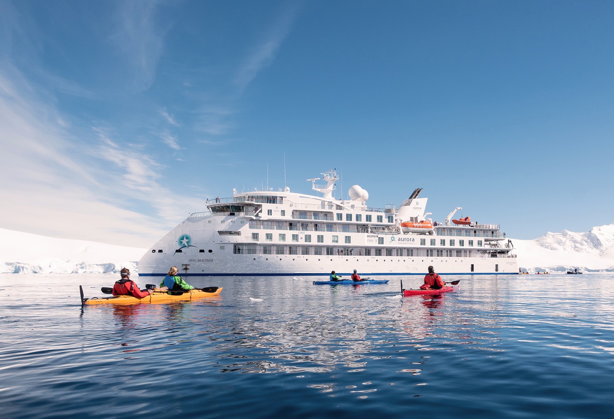 Kayakers in Norway in front of the Greg Mortimer