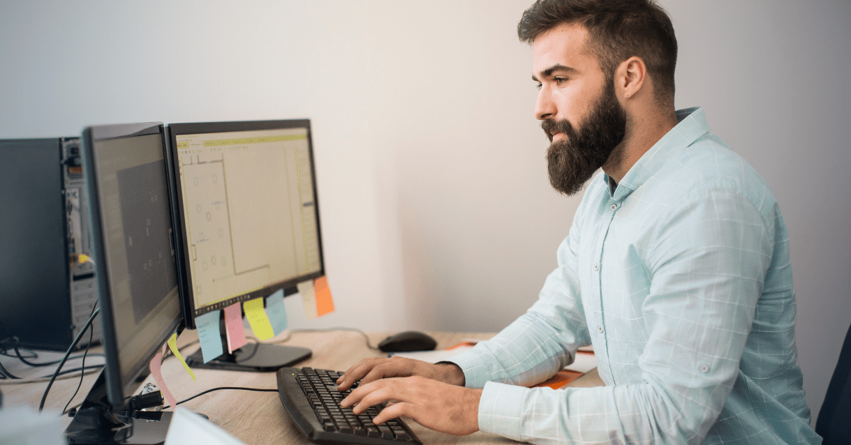 Man typing on a desktop computer