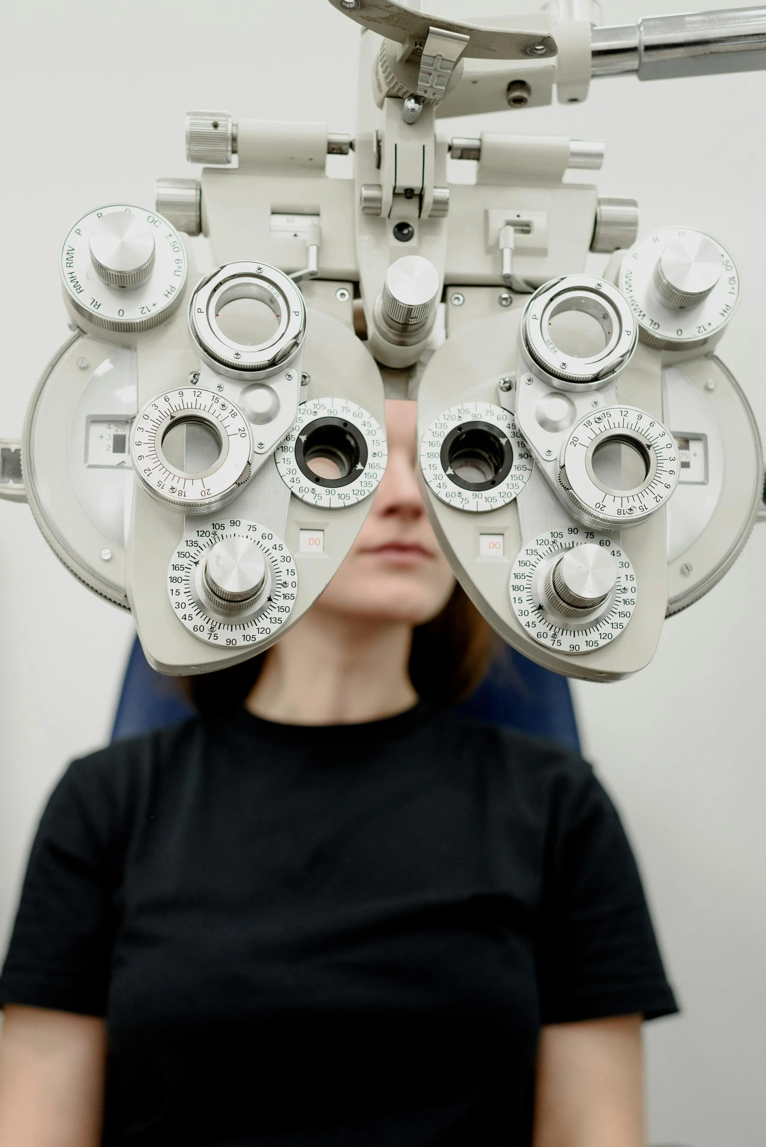 A patient having their vision tested behind a phoropter