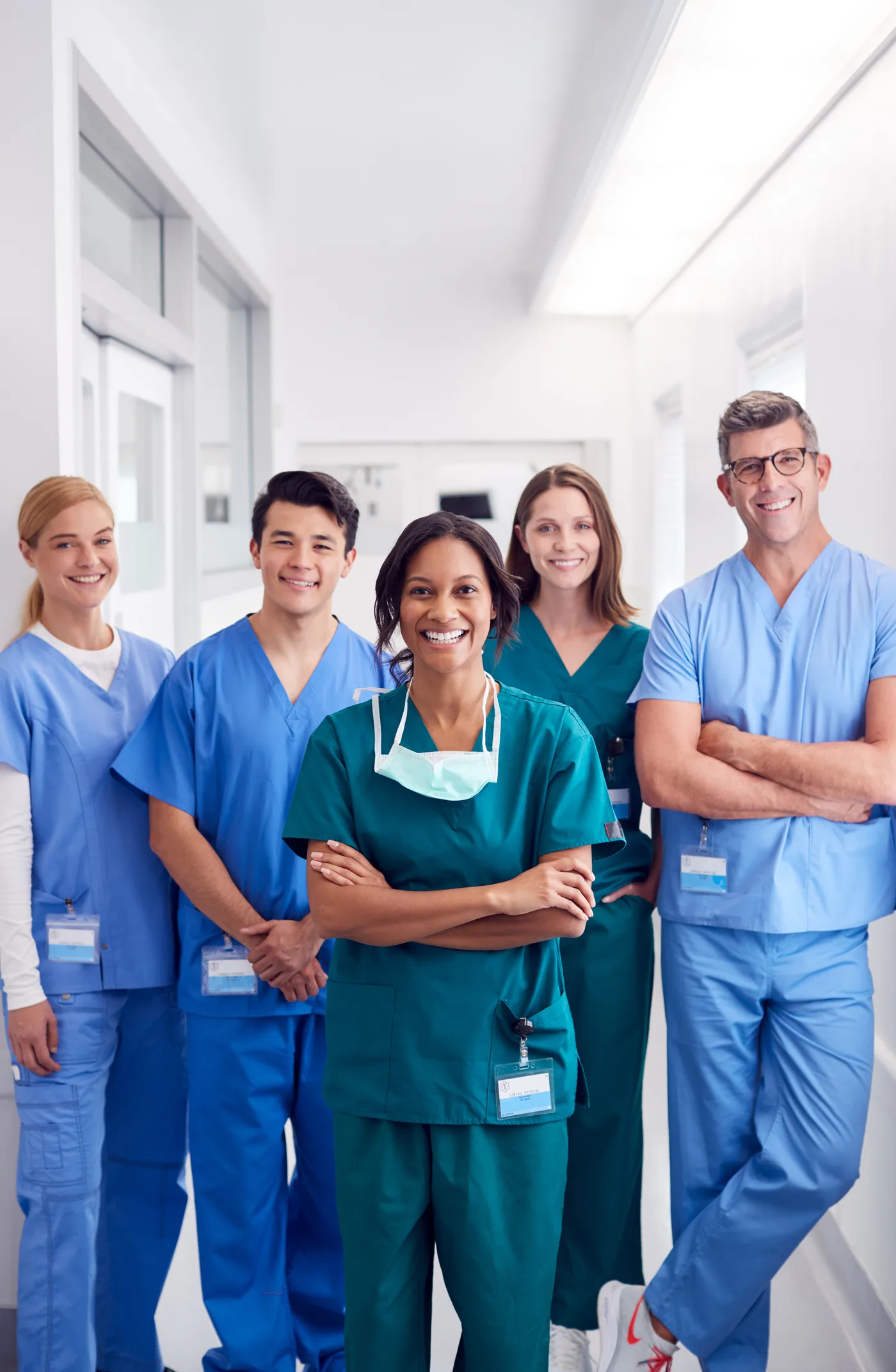 A team of clinicians in scrubs standing together in a hospital corridor