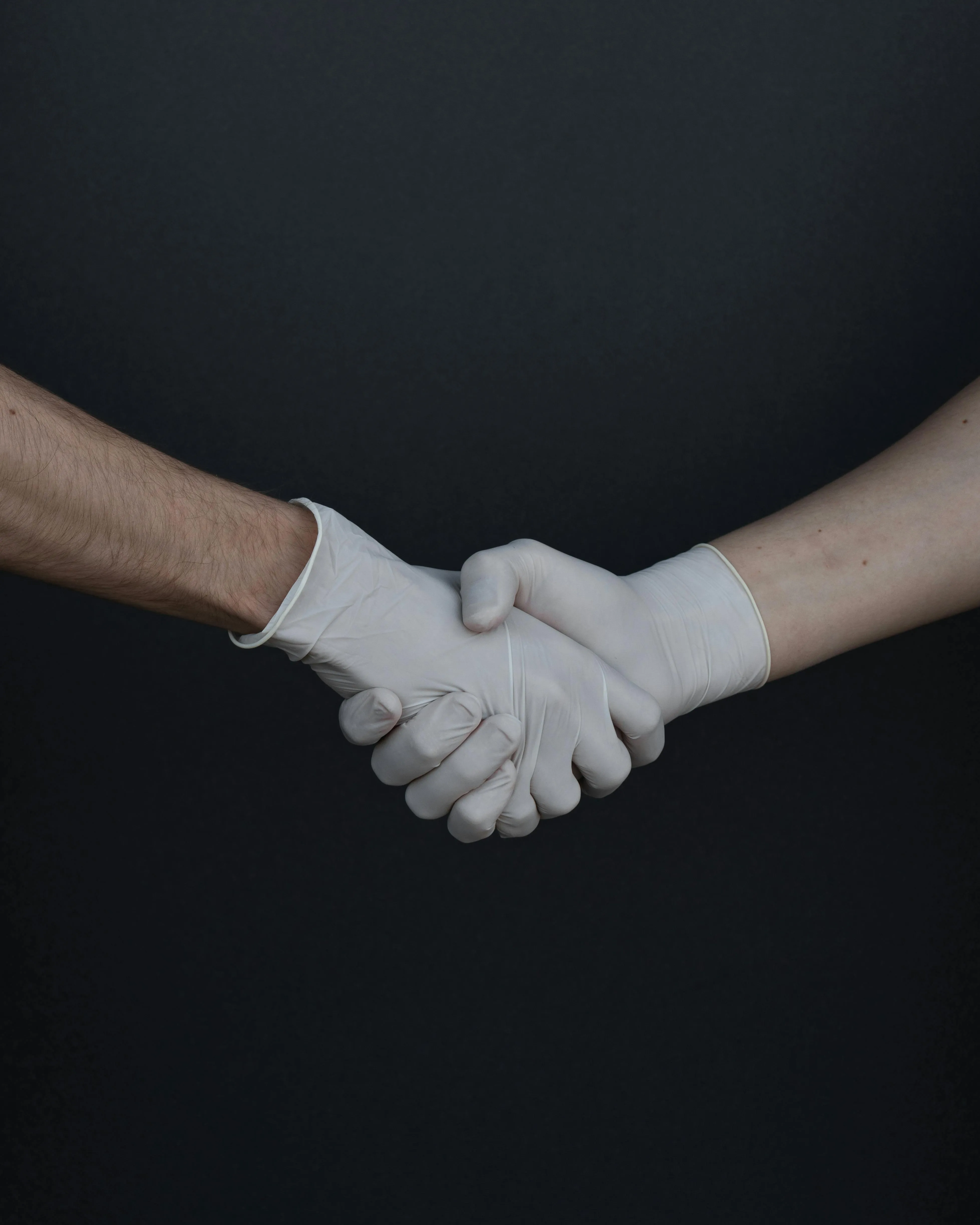 Two people in surgical gloves shaking hands