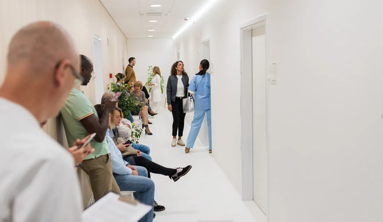 Patients and staff in a busy specialist clinic waiting area