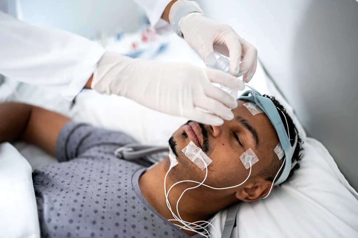 A sleep technician attaching electrodes to a patient before an overnight sleep study