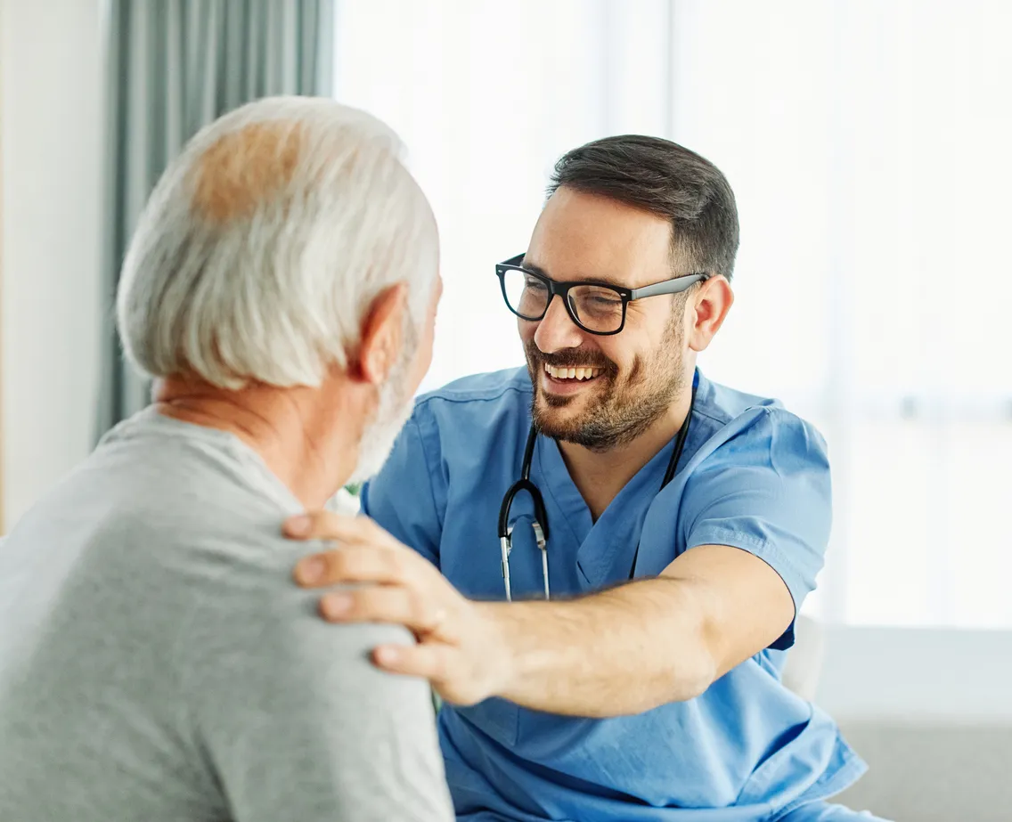 A clinician talking warmly with an older patient during a consultation