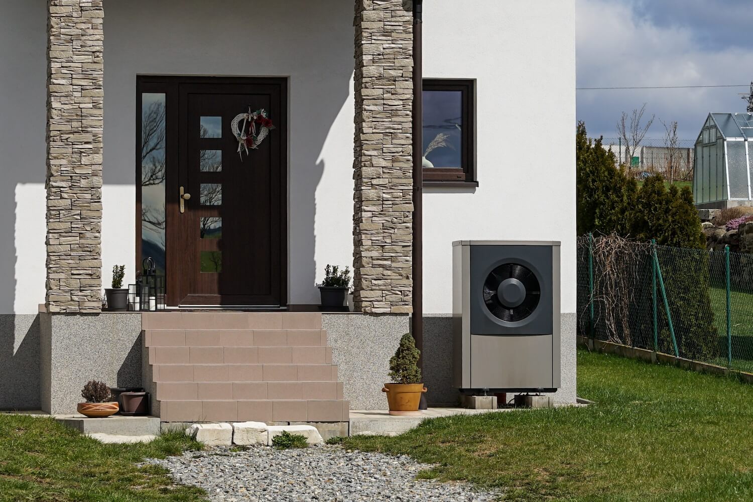 Eine Propan-Wärmepumpe steht vor einem Wohnhaus.
