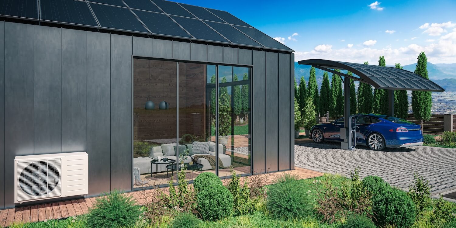 Modernes Haus mit Wärmepumpe in Kaskadenschaltung und Solarpanelen auf Dach und Carport, neben einem Elektroauto.