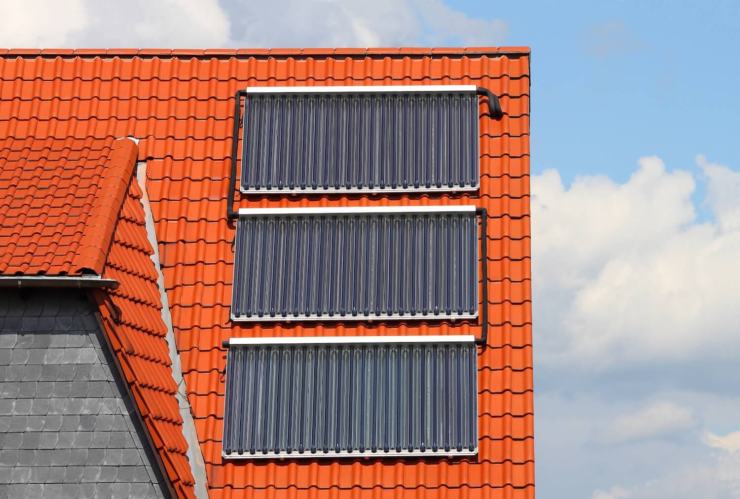 Wer seine Heizung erneuern möchte, kann wie hier Solarthermie-Kollektoren auf dem Dach installieren und von kostenloser Sonnenenergie profitieren.