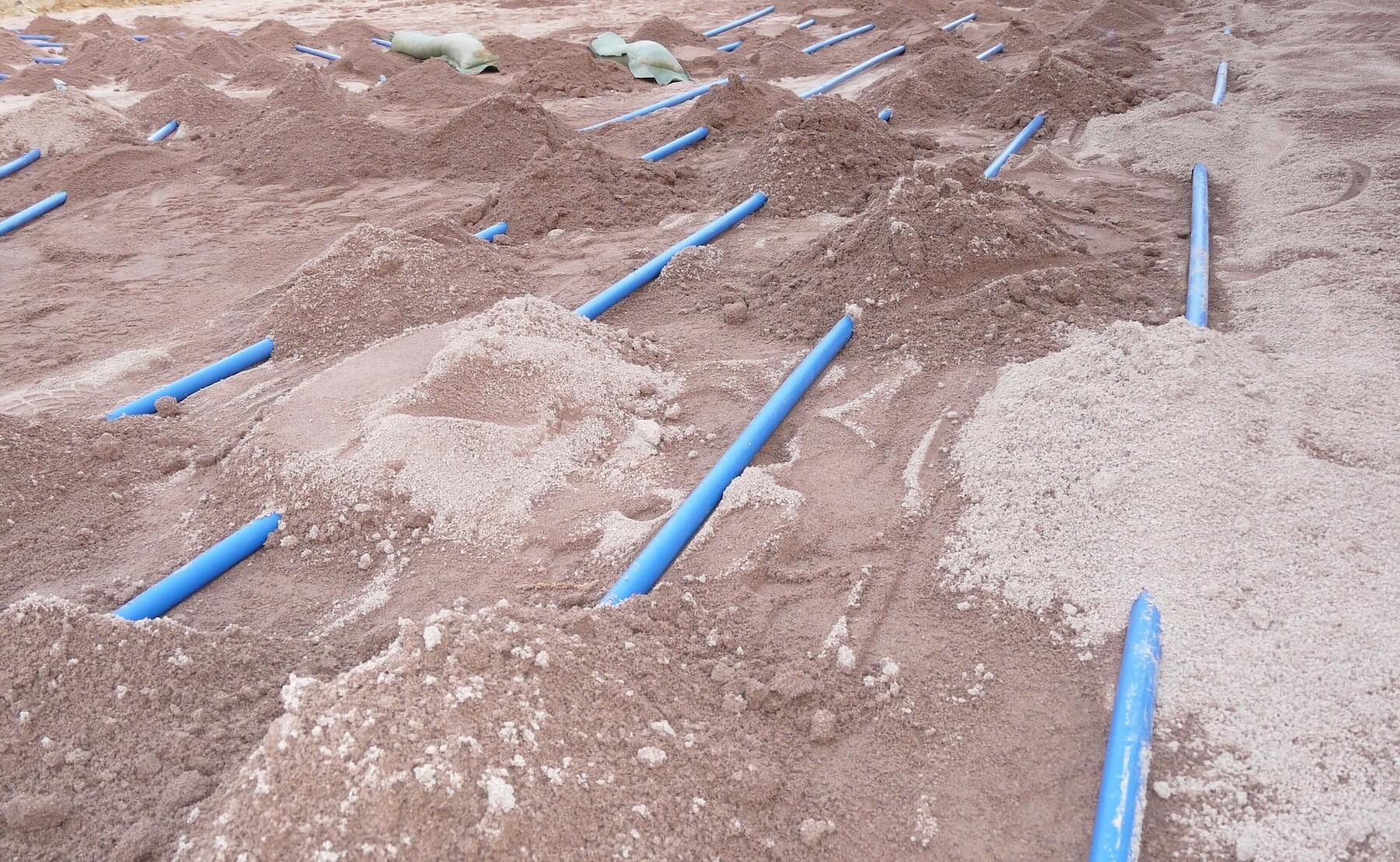 Draufsicht auf die verlegten schlaufenförmig verlegten Kunststoffrohre der Erdkollektoren