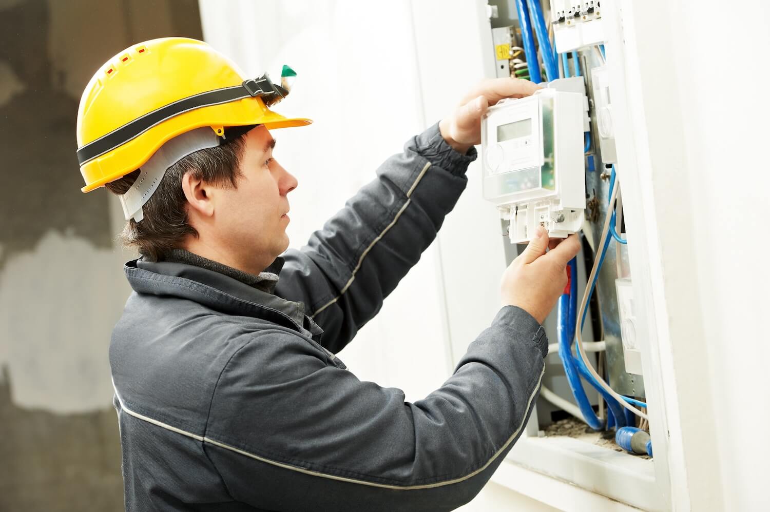 Ein Elektriker installiert einen digitalen Stromzähler.