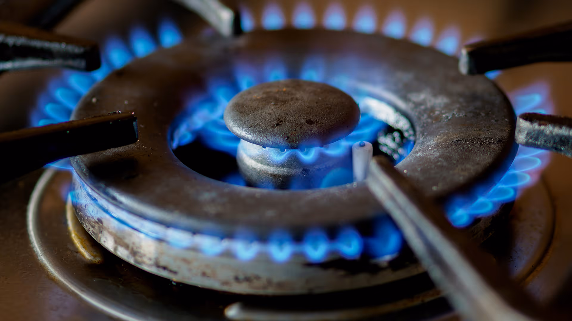 Eine blaue Flamme auf einem Gasherd.