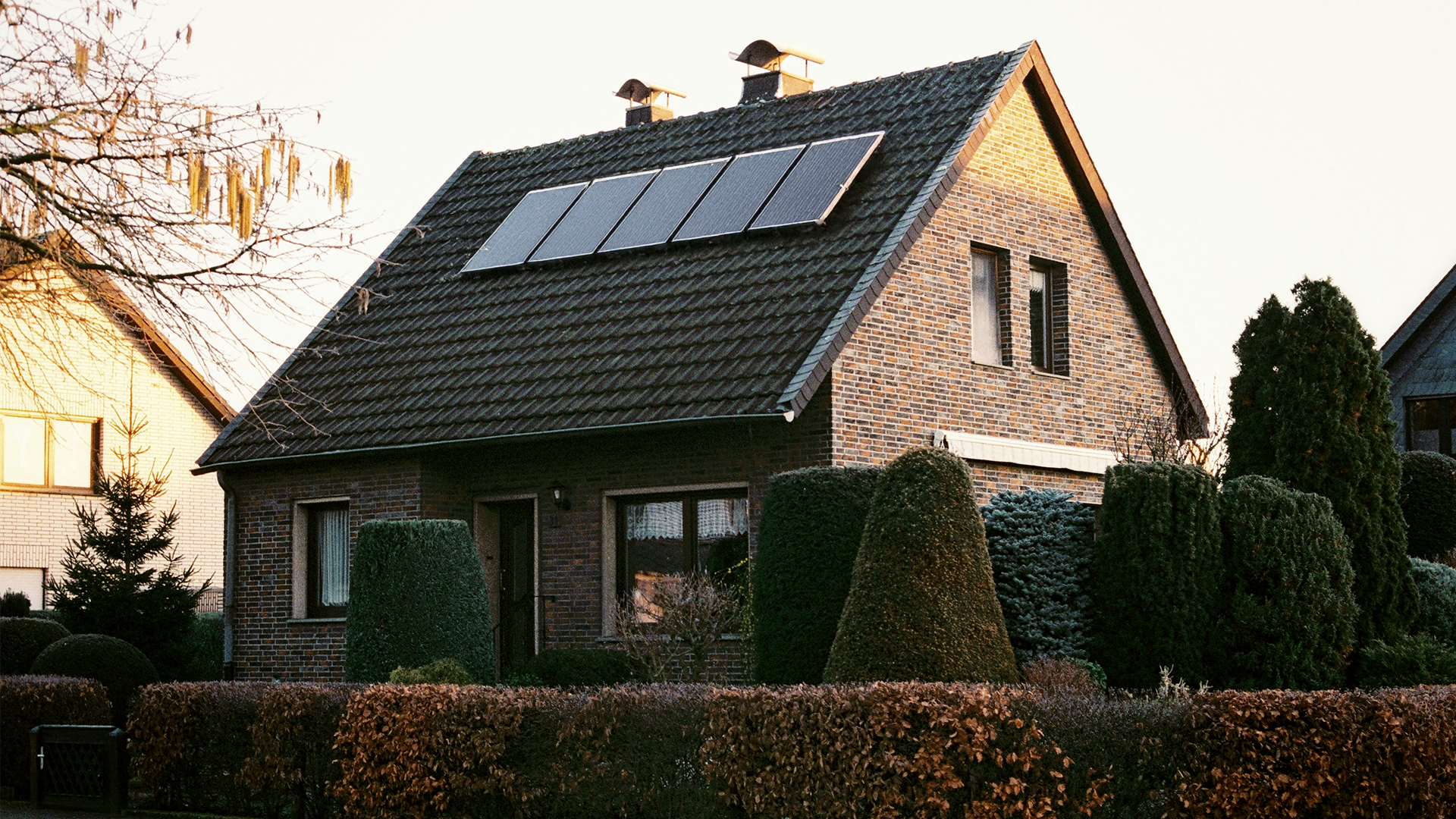 Einfamilienhaus mit große Vorgarten und Photovoltaikanlage auf dem Dach.