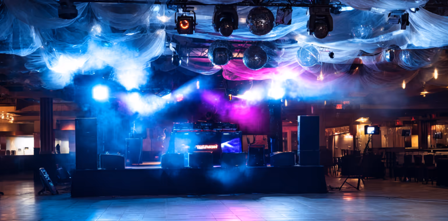 Empty nightclub stage with colorful blue and purple spotlights, disco balls, and fog effects.