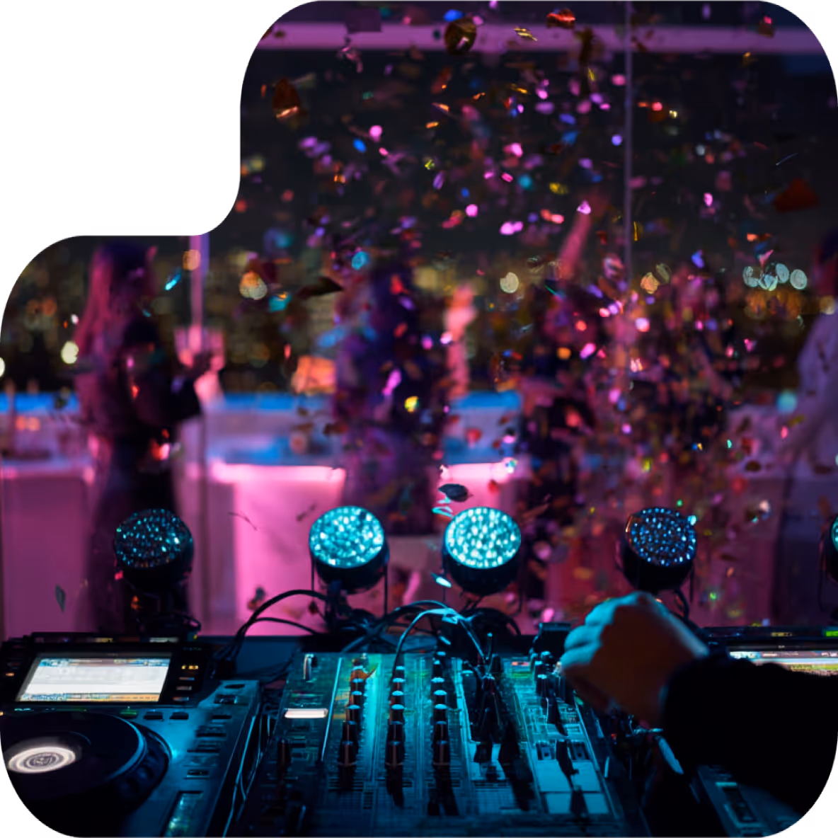 DJ mixing music on a console with colorful stage lights and confetti falling at a lively party.